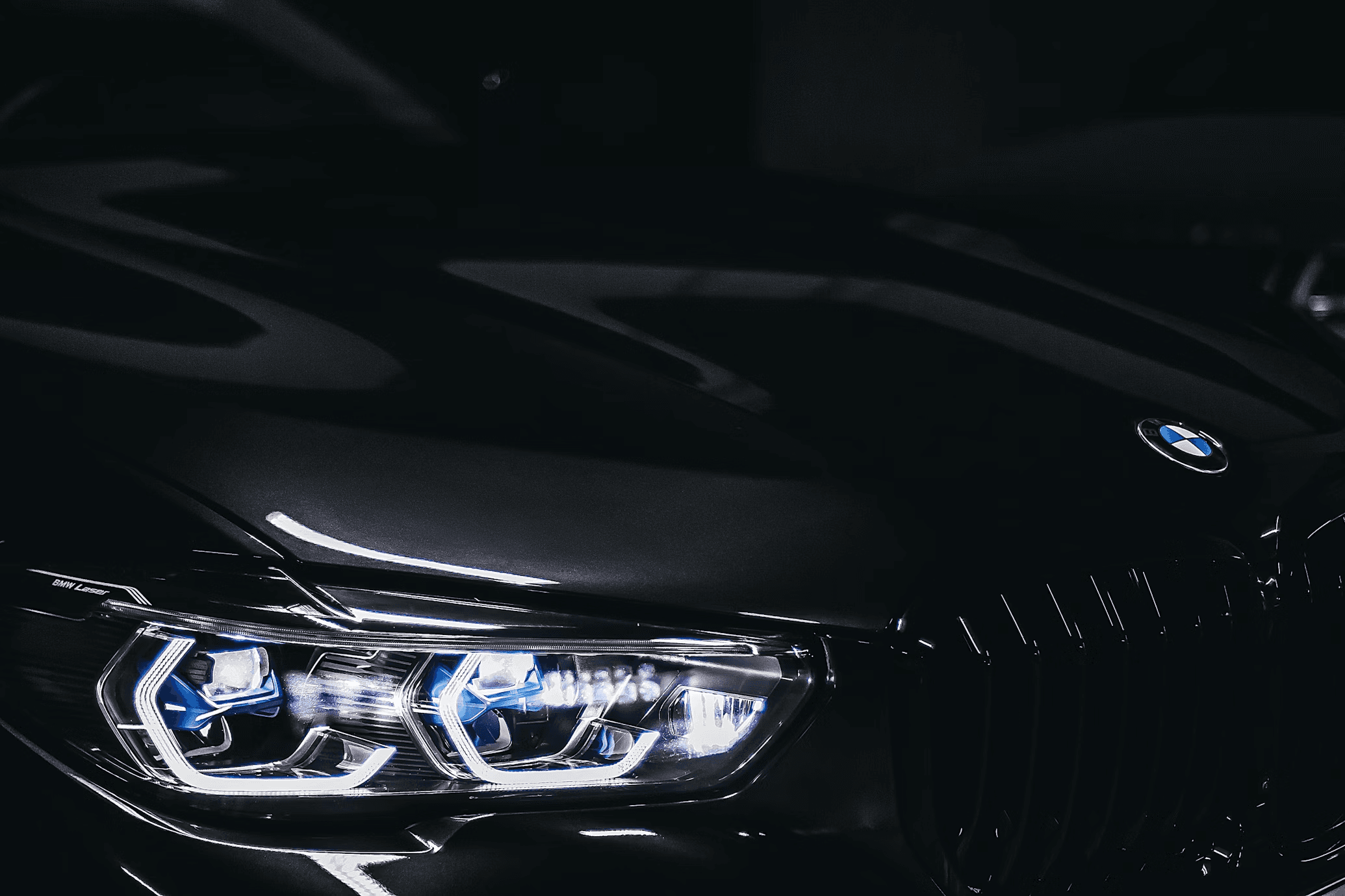Close up of a dark luxury car hood and headlights